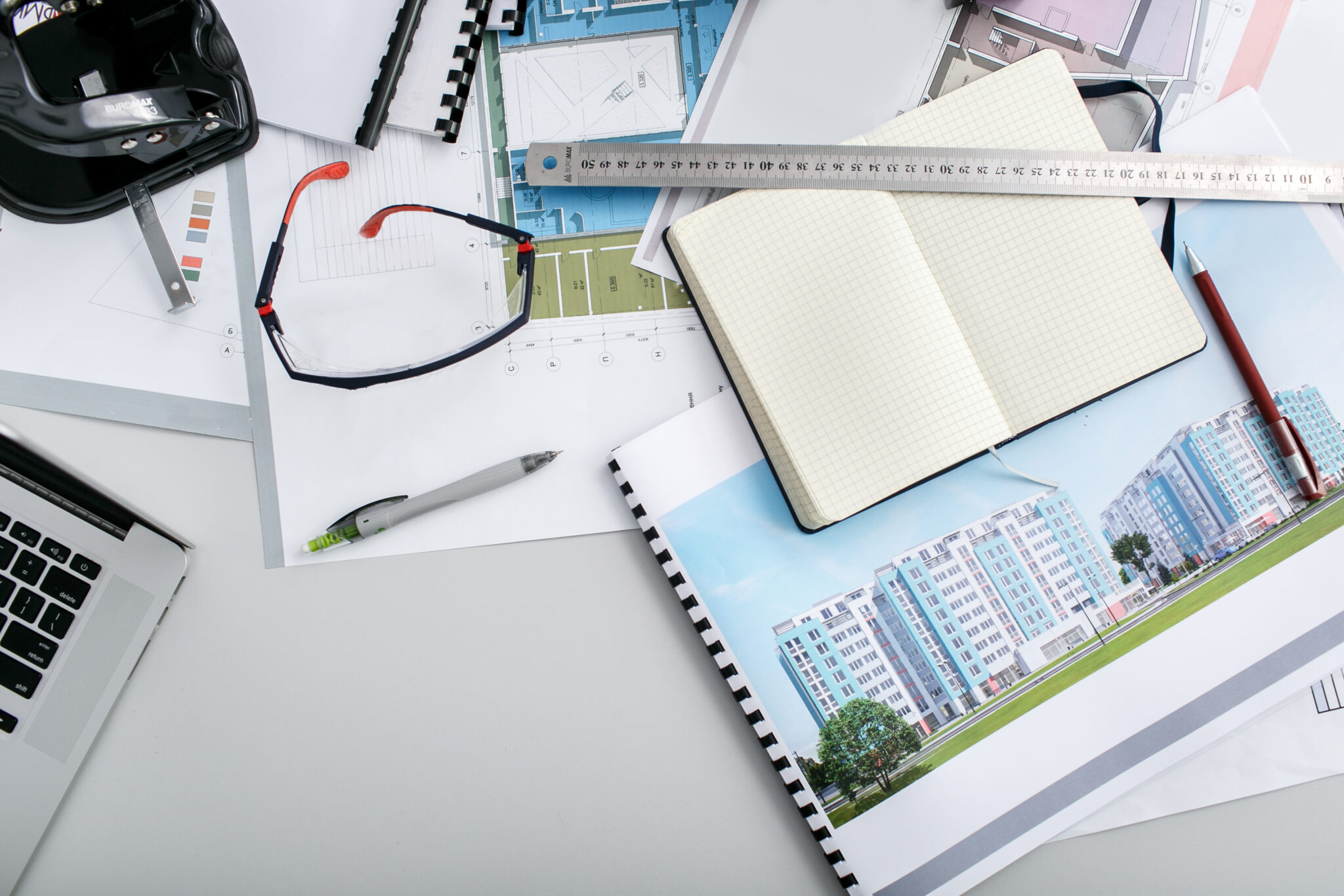 Maps, notebook, ruler and pens lie on office table